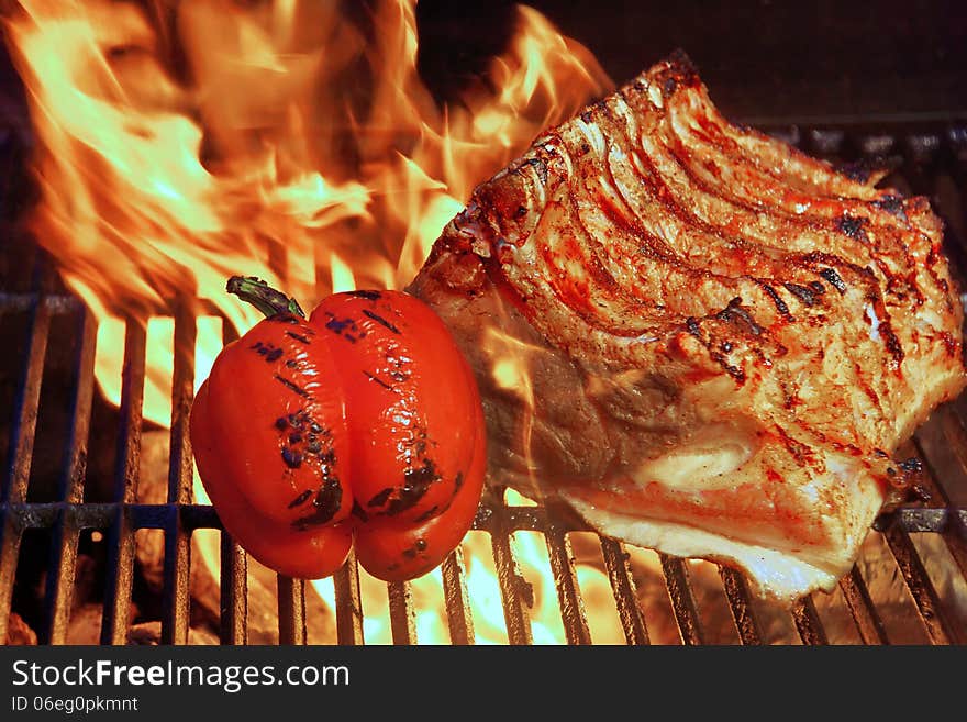 Ribs roasted in a barbecue with pepper and tomatoes