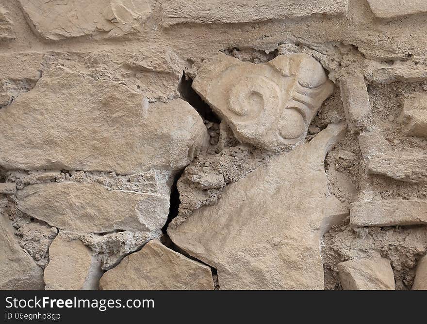 Ancient wall with an older fragment of a column in it