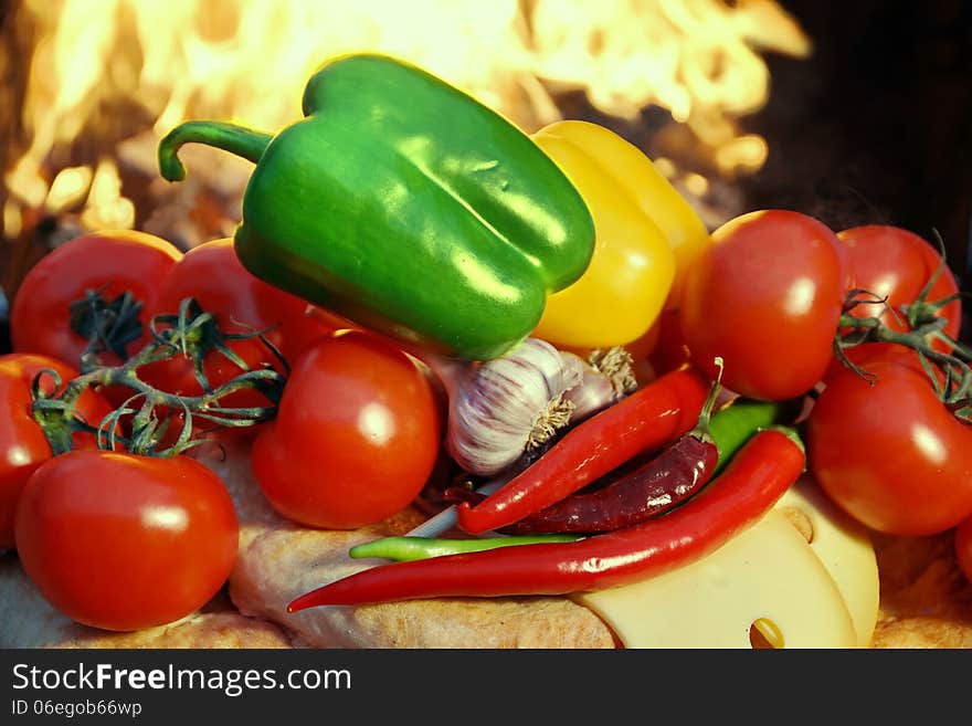 Clorful Bell and hot peppers, tomatoes, bread and garlic near BBQ cast iron grill. Clorful Bell and hot peppers, tomatoes, bread and garlic near BBQ cast iron grill