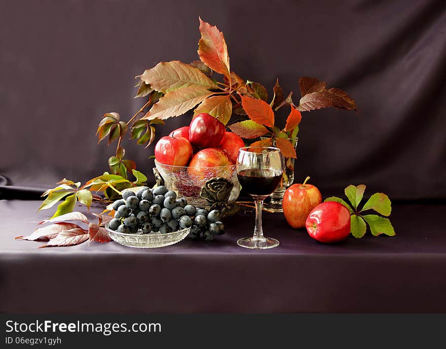 Grapes, apples, nuts and a glass of red wine