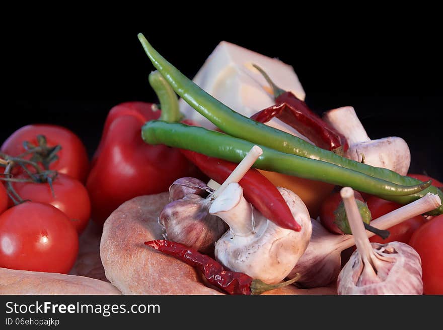 Fresh bread and vegetables on a black background