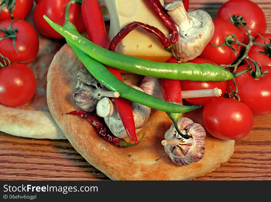 Fresh bread and vegetables on a wooden panel