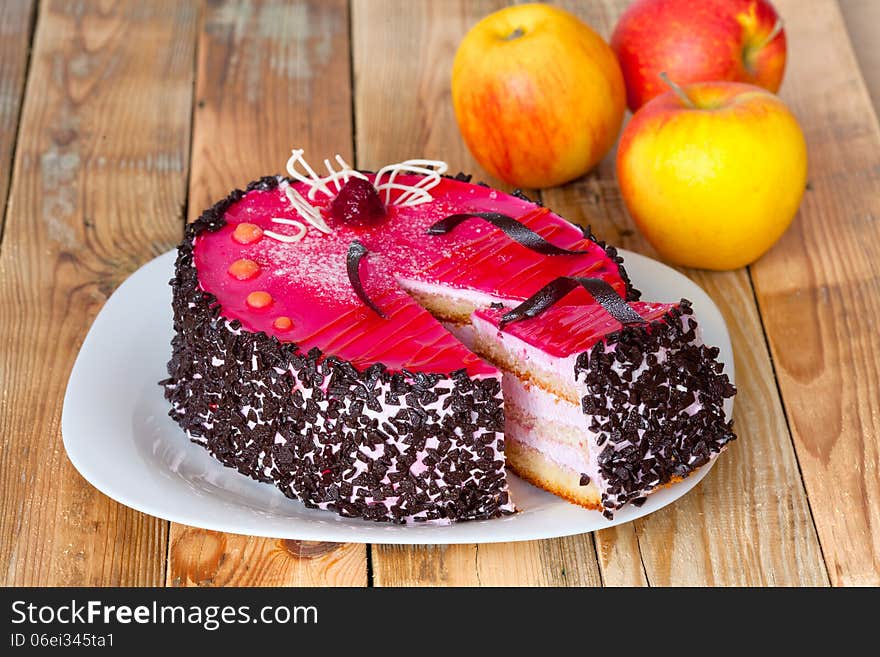 Jelly cake with whipped cream on a wooden table with apples. Jelly cake with whipped cream on a wooden table with apples