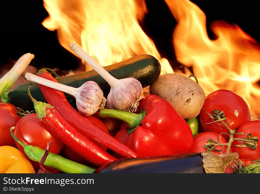 Assorted fresh vegetables in a pile before the flame from BBQ facilities. Assorted fresh vegetables in a pile before the flame from BBQ facilities