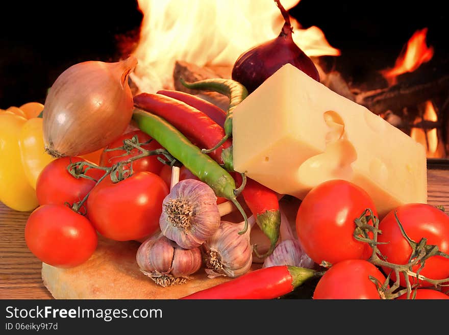 Fresh Bread Cheese and Vegetables on a Wooden Panel before the flame from BBQ facilities. Fresh Bread Cheese and Vegetables on a Wooden Panel before the flame from BBQ facilities