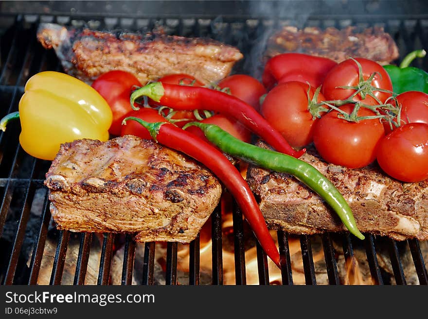 Ribs and brisket roasted in a barbecue with vegetables. Ribs and brisket roasted in a barbecue with vegetables