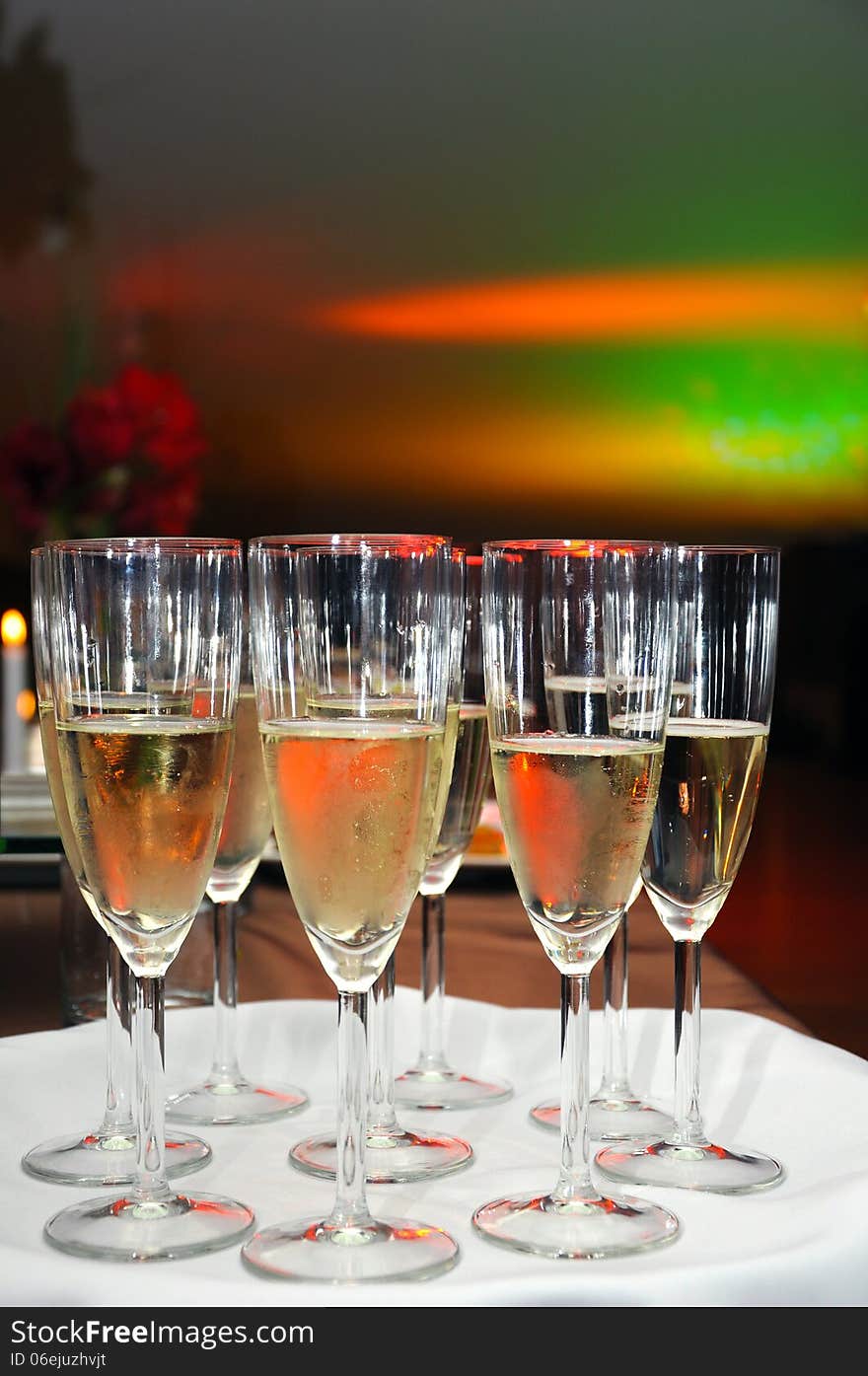 A number of champagne glasses filled with bubbles, waiting to be served at a reception. A number of champagne glasses filled with bubbles, waiting to be served at a reception.