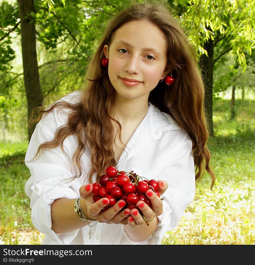 Sweet girl holding a handful of ripe cherry