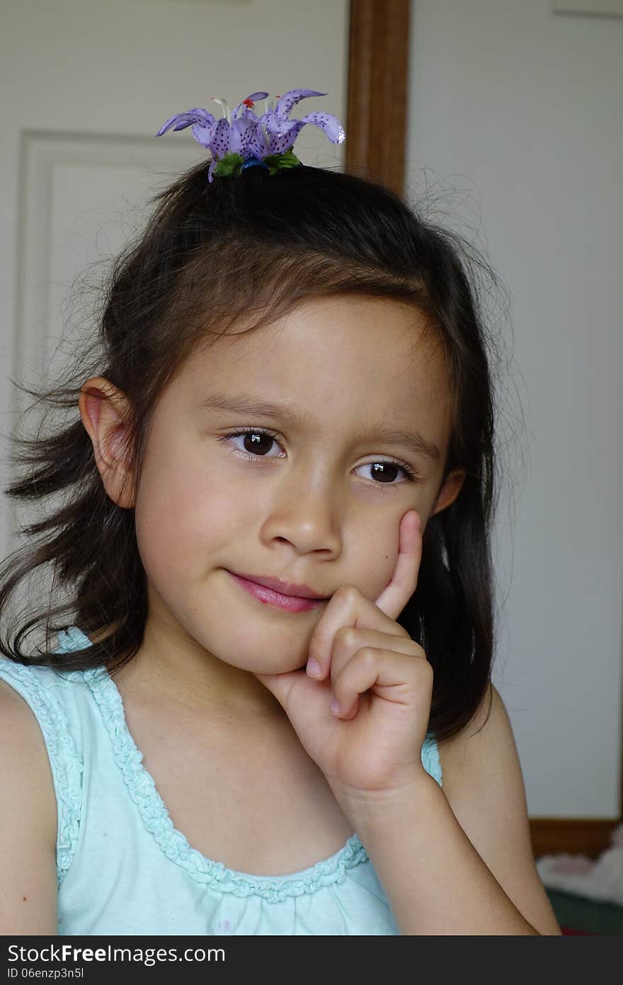 A young Asian girl looks concerned and unhappy as she places her left hand under her chin. A young Asian girl looks concerned and unhappy as she places her left hand under her chin.