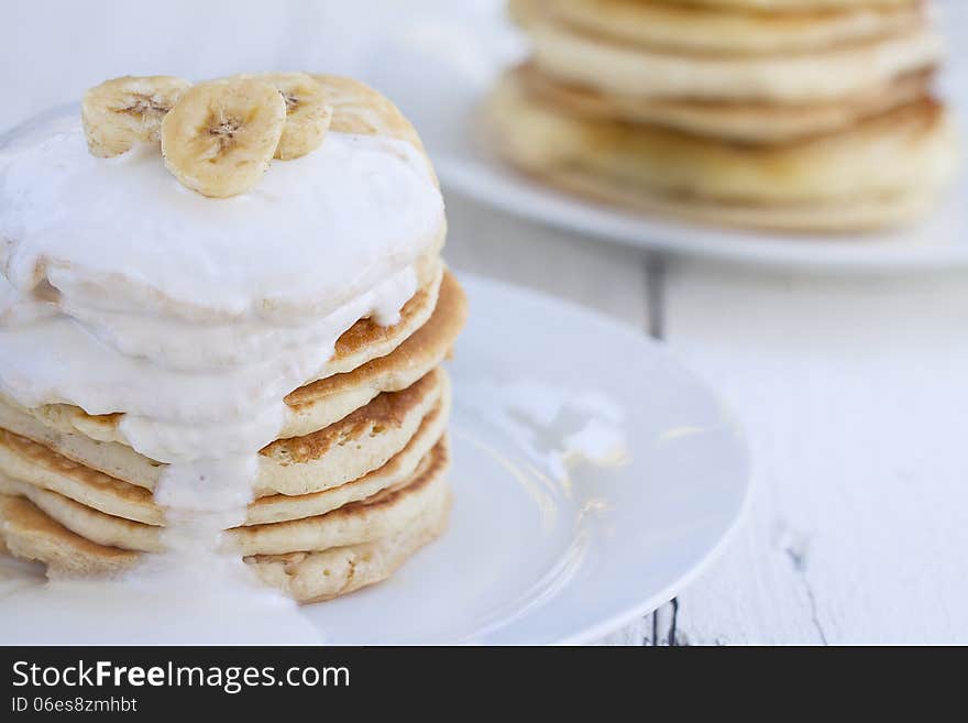 Stacks of Pancakes with sour cream and pieces of banana