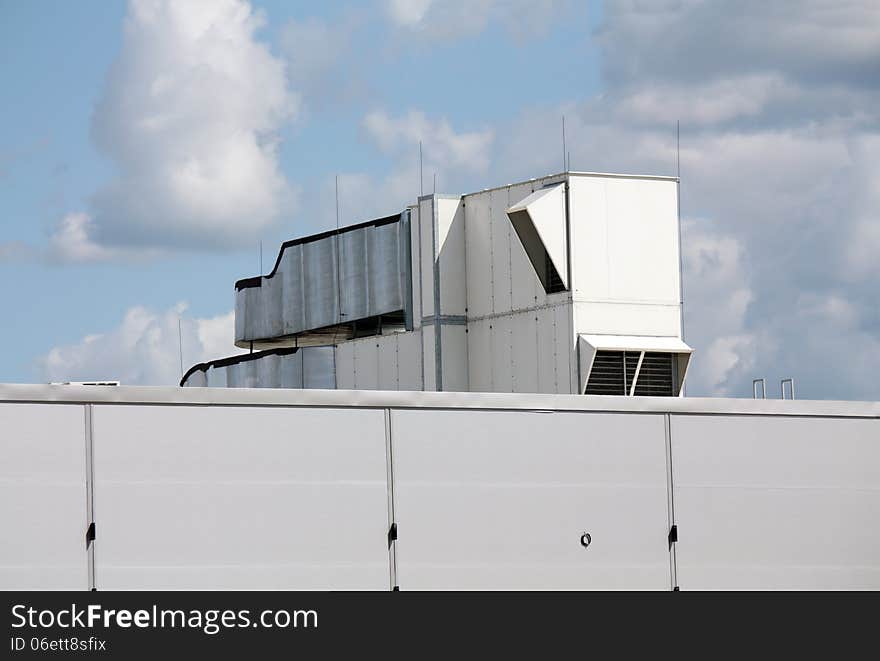 Ventilation pipes and actuators on the roof of an industrial building. Ventilation pipes and actuators on the roof of an industrial building