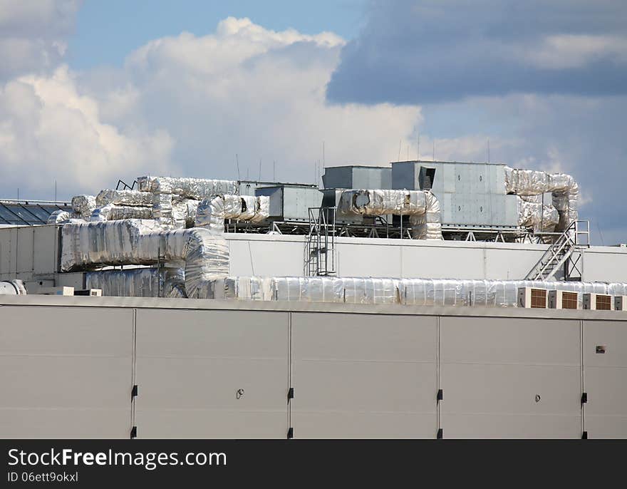 Ventilation pipes and actuators on the roof of an industrial building. Ventilation pipes and actuators on the roof of an industrial building