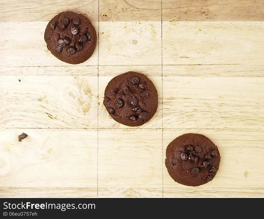 Winner cross line pattern of xo game, play by dark brown cookies on wood background. Winner cross line pattern of xo game, play by dark brown cookies on wood background.