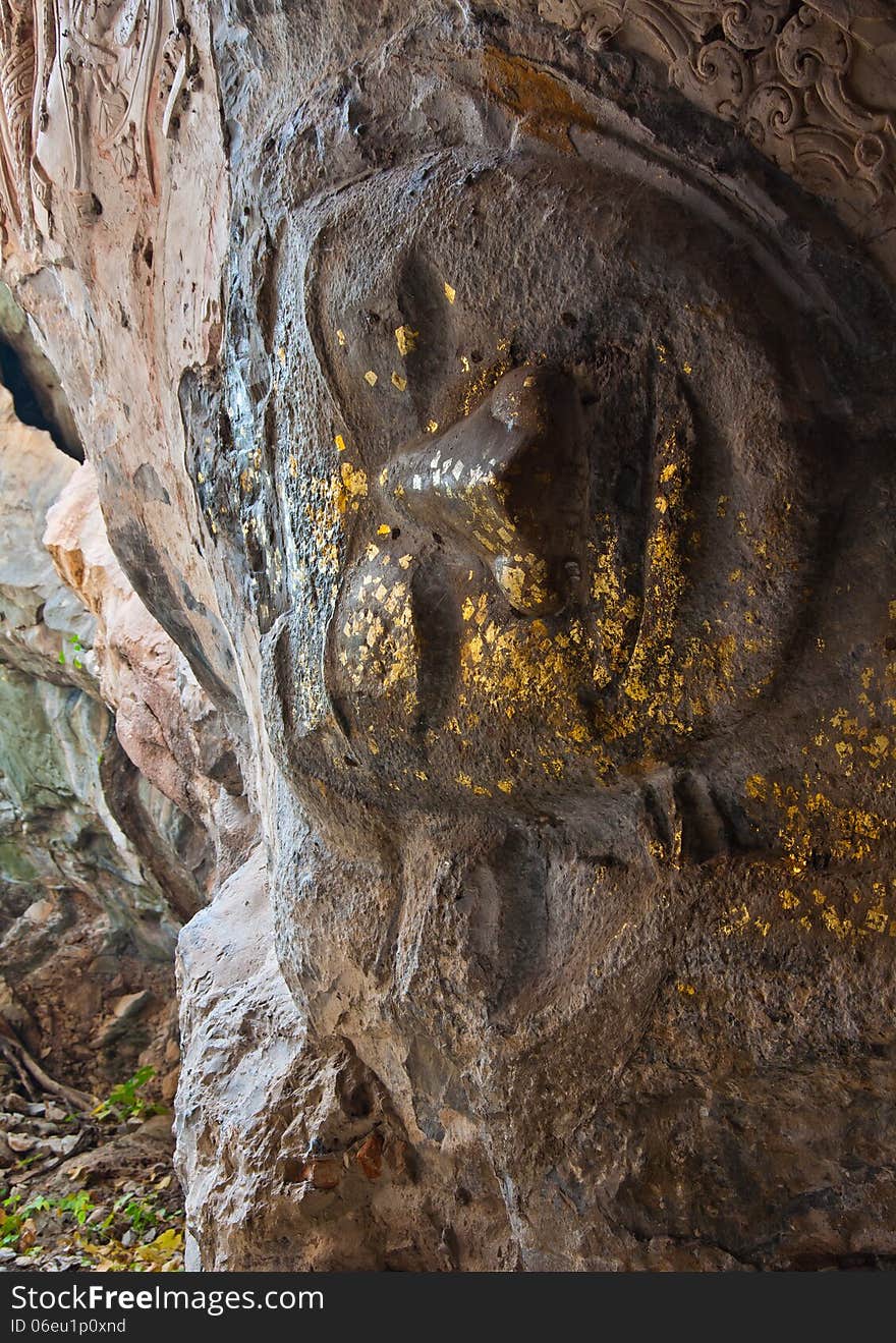 The stucco of ancient reclining Buddha at the Khao Ngu Cave in T