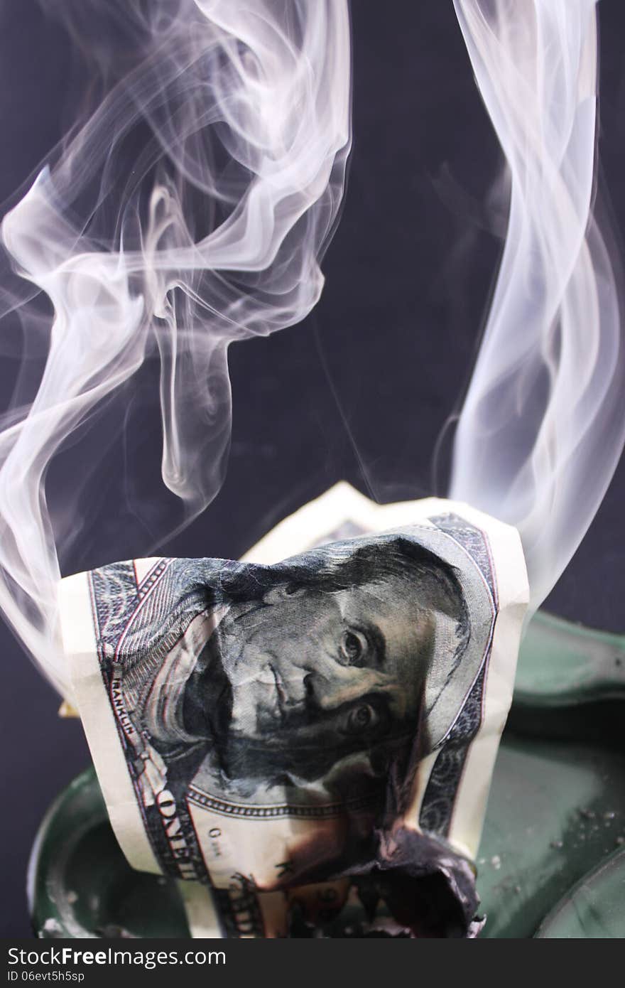 Burning dollar bill as a symbol of inflation and the financial crisis