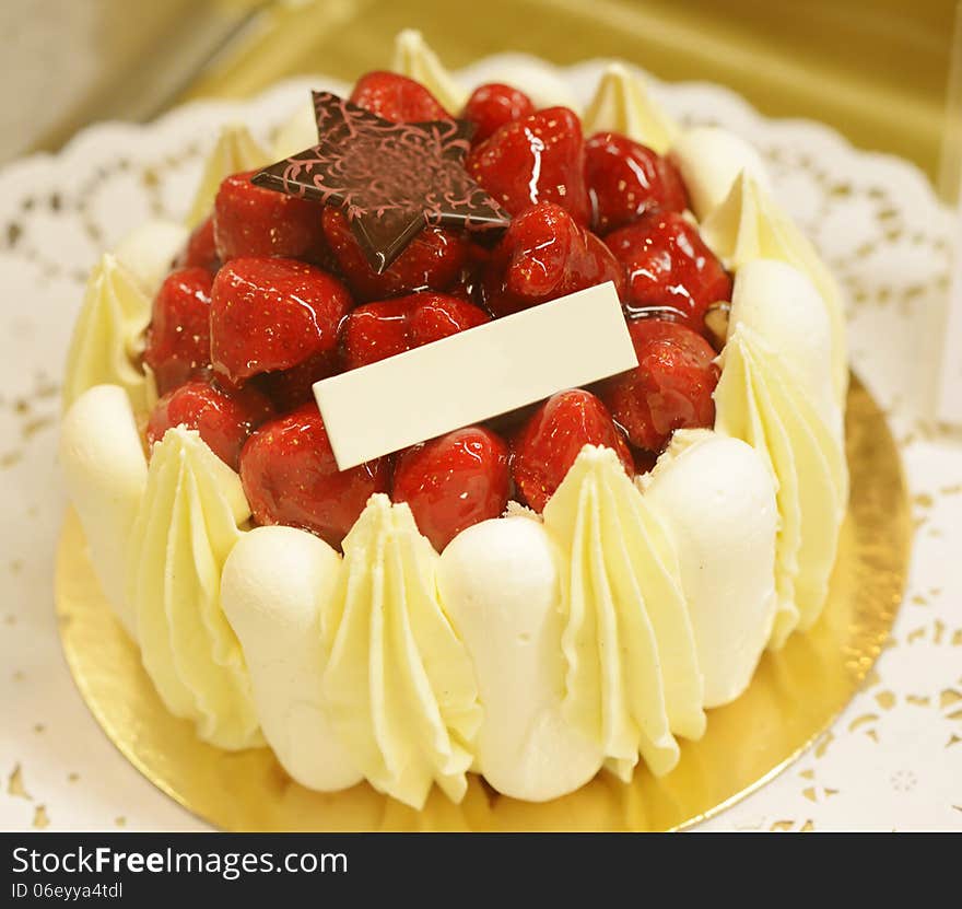 Small little strawberry cheesecake with empty label for advertise. Image taken in a bakery as a closeup.