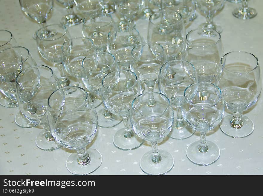 Many empty glasses in a line on table.