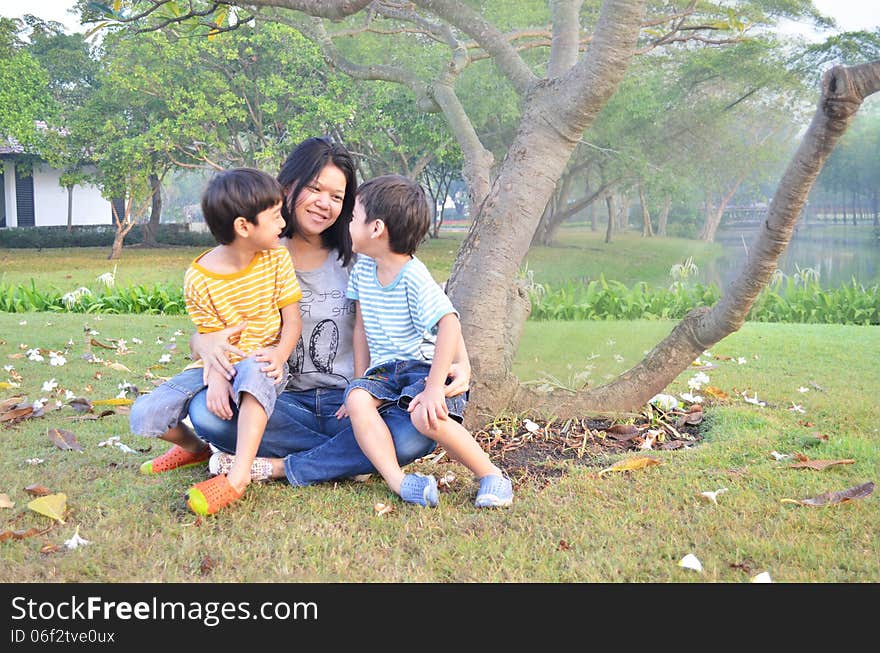 Mother and sons sit together in the park. Mother and sons sit together in the park