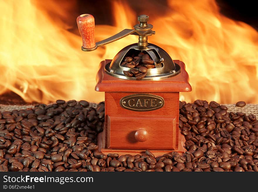 Retro Grinder and roasted Coffee Beans on Burlap at the Fireplace. Retro Grinder and roasted Coffee Beans on Burlap at the Fireplace