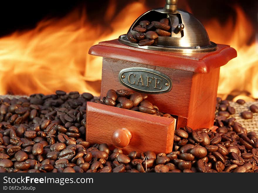 Retro Grinder and Coffee Beans on Burlap at the Fireplace. Retro Grinder and Coffee Beans on Burlap at the Fireplace