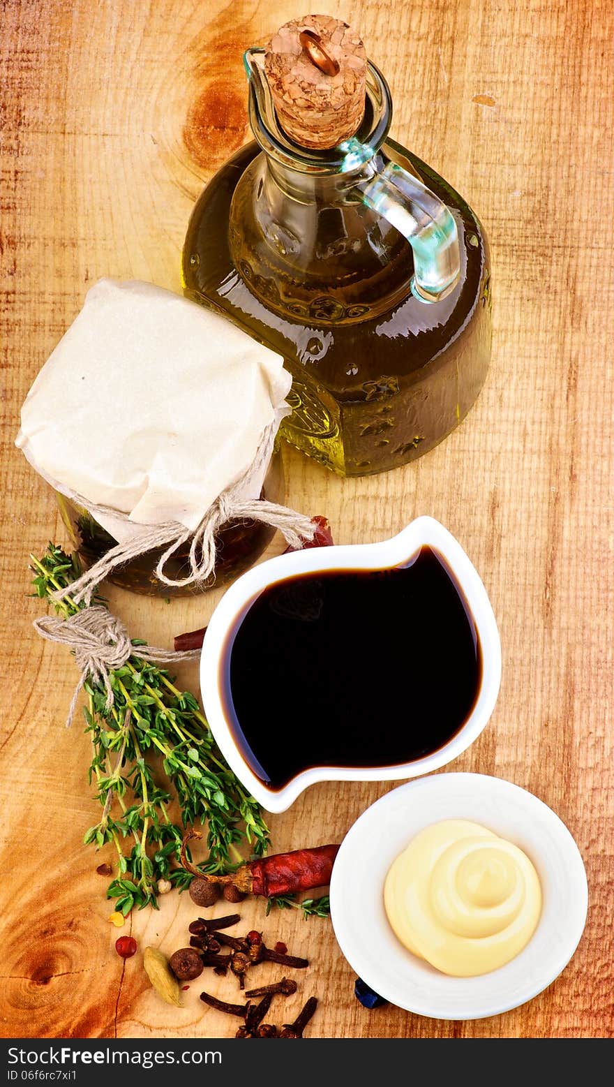 Ingredient for Cooking Salad Sauce with Olive Oil, Spices, Herbs and Mayonnaise closeup on Wooden background. Top View. Ingredient for Cooking Salad Sauce with Olive Oil, Spices, Herbs and Mayonnaise closeup on Wooden background. Top View