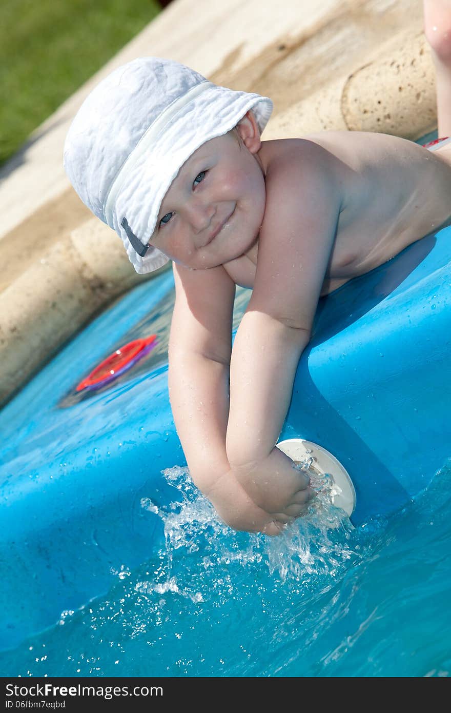 Cute toddler by a swimming pool. Cute toddler by a swimming pool