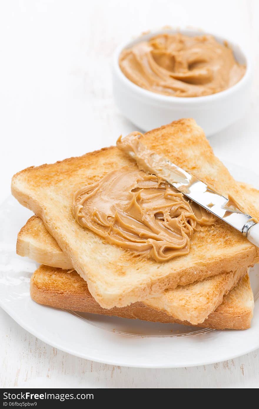 Toast with peanut butter, vertical, close-up