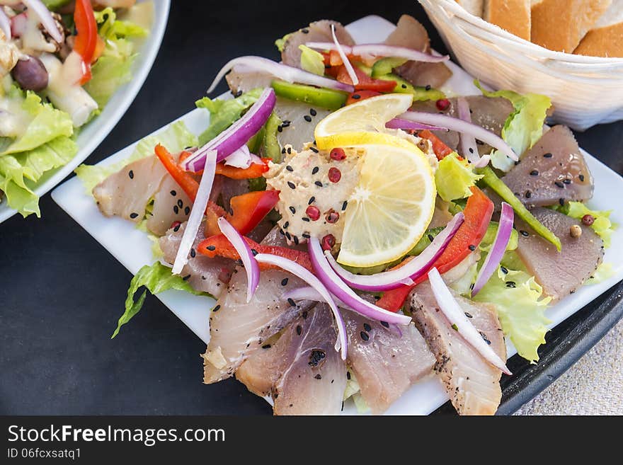 Smoked tuna fish served with baguette and salad. Smoked tuna fish served with baguette and salad.