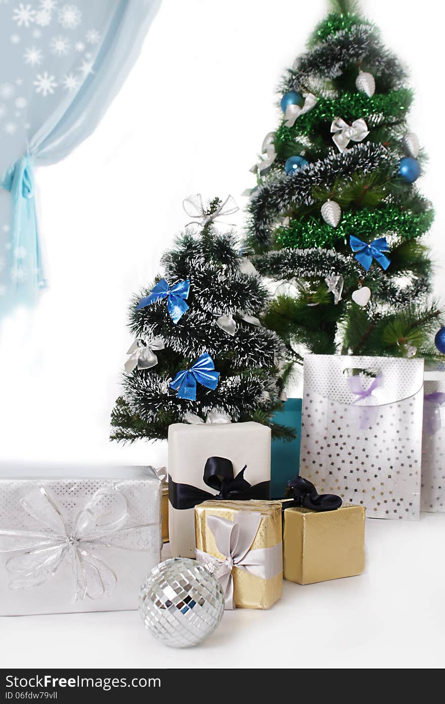 Christmas tree decorated with blue ornaments and presents over white