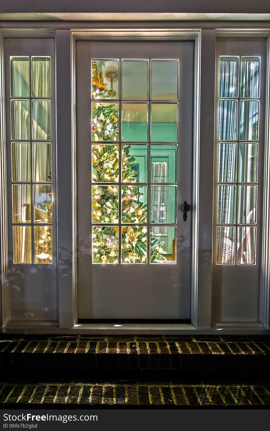 Christmas tree in living room viewing thru a front door entrance