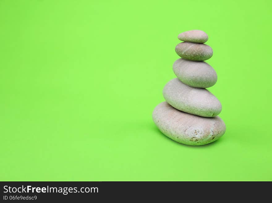 Pyramid of stones on green background