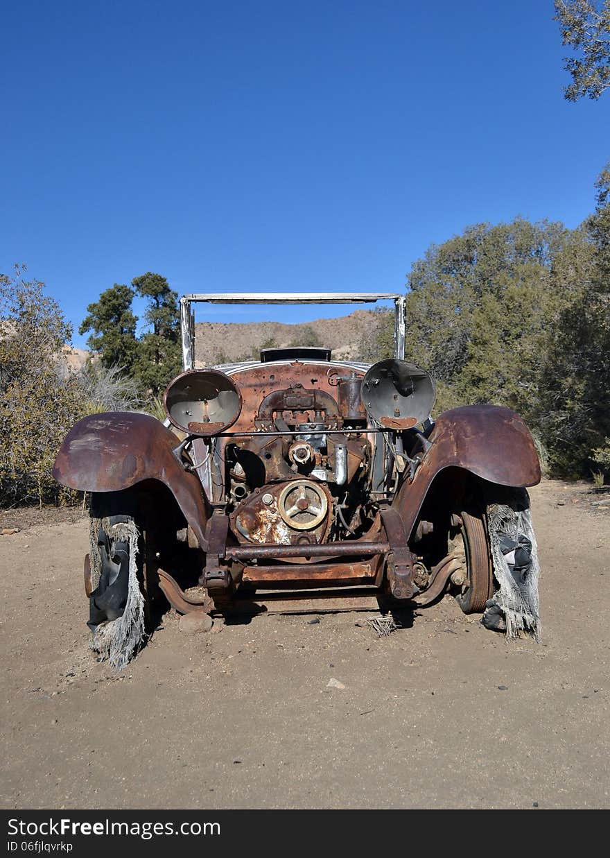 An antique auto sits on the desert floor. An antique auto sits on the desert floor