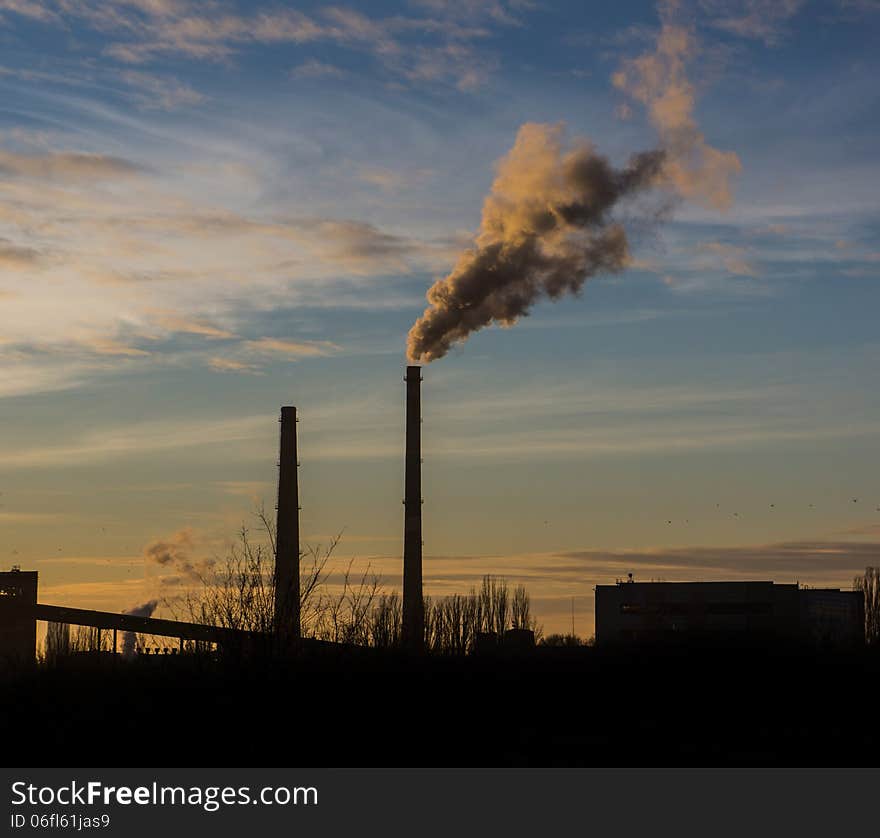 Pipe throws industrial waste gases on the background of the evening sky. Pipe throws industrial waste gases on the background of the evening sky