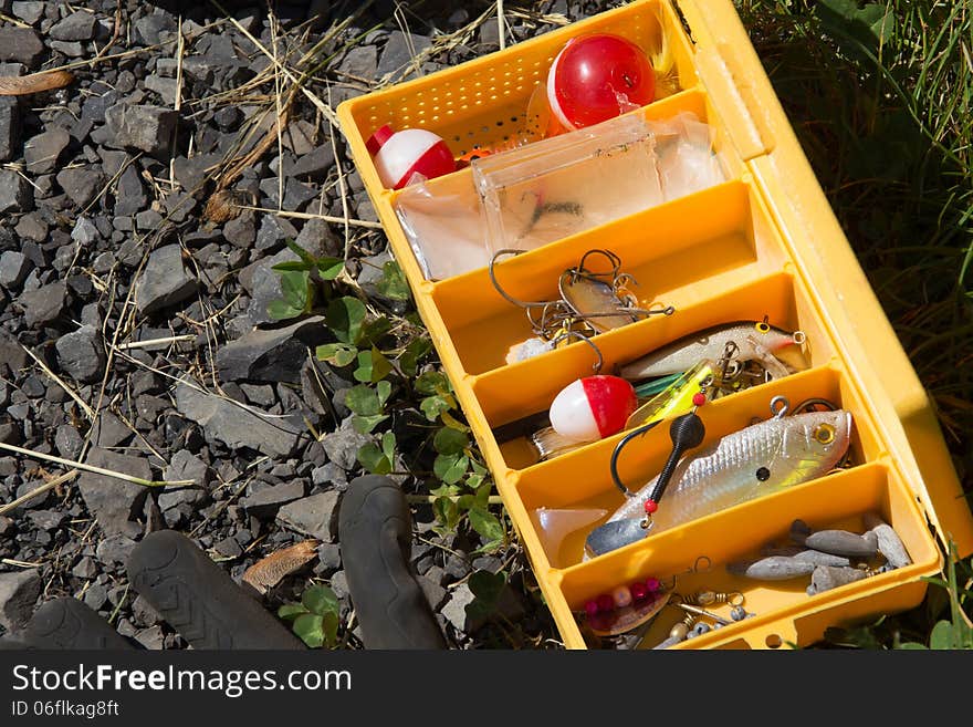 Open yellow fishing box on ground