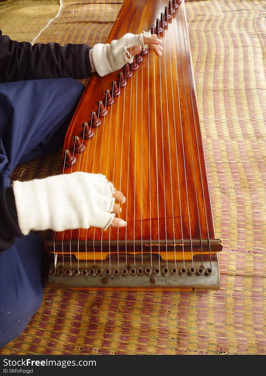 An elderly man playing a harp on a white crater area,