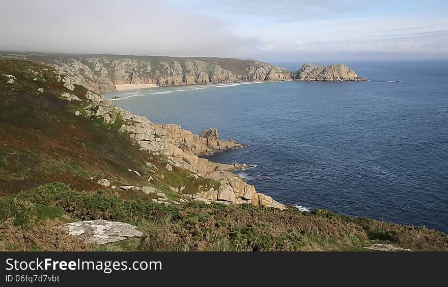 Coast of Cornwall England in autumn with mist and blue sky near the Minack Theatre and Porthcurno