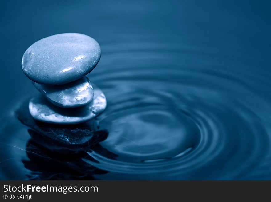 Meditation concept. Stack of stones on dark calm water. Meditation concept. Stack of stones on dark calm water