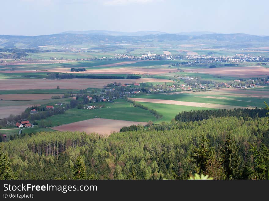 Czech landscape with green and brown field, trees and a village, rural landscape. Czech landscape with green and brown field, trees and a village, rural landscape