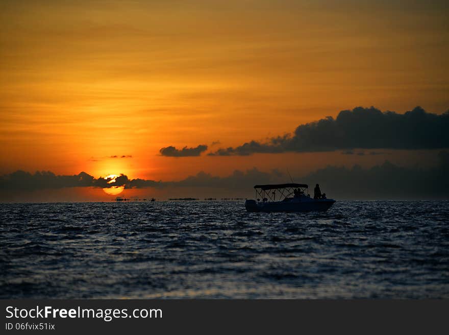 Famous sunset at Key West, FL with boat silhouette against the sun