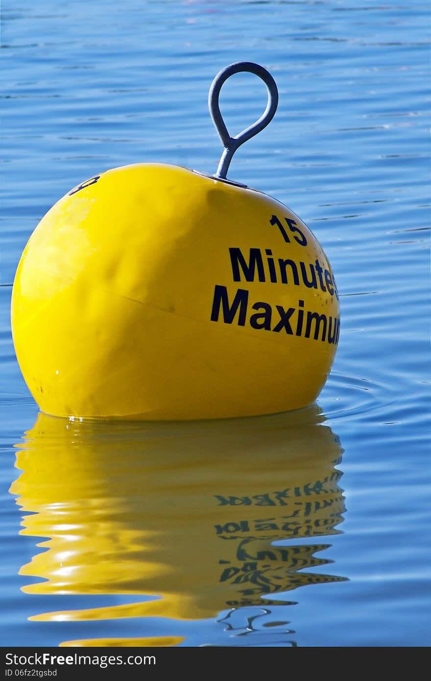 Mooring restriction sign on a yellow buoy floating in blue water at the harbour. Mooring restriction sign on a yellow buoy floating in blue water at the harbour.