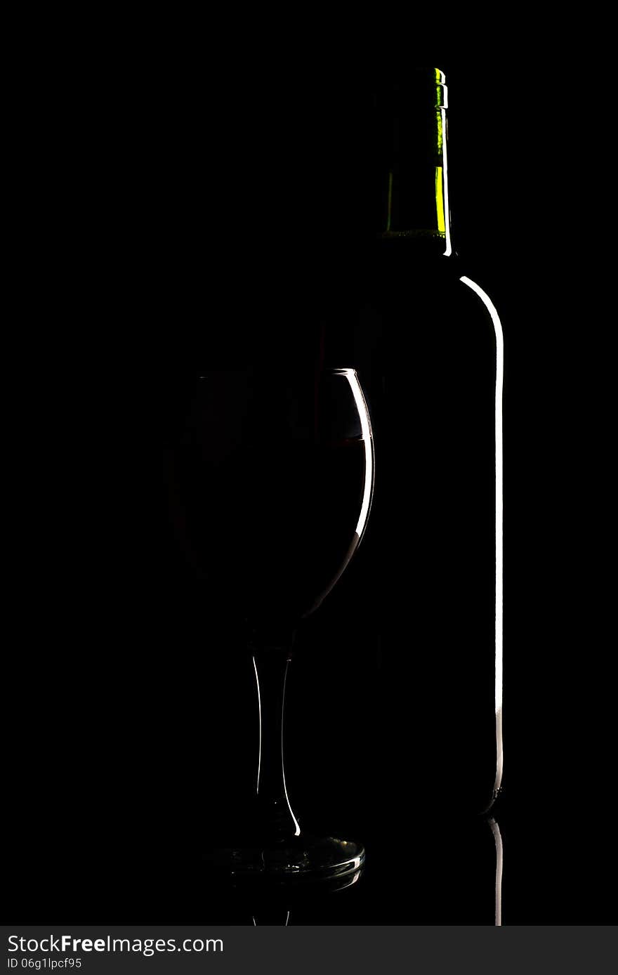 Wine Bottle And Glass Silhouette Over Black