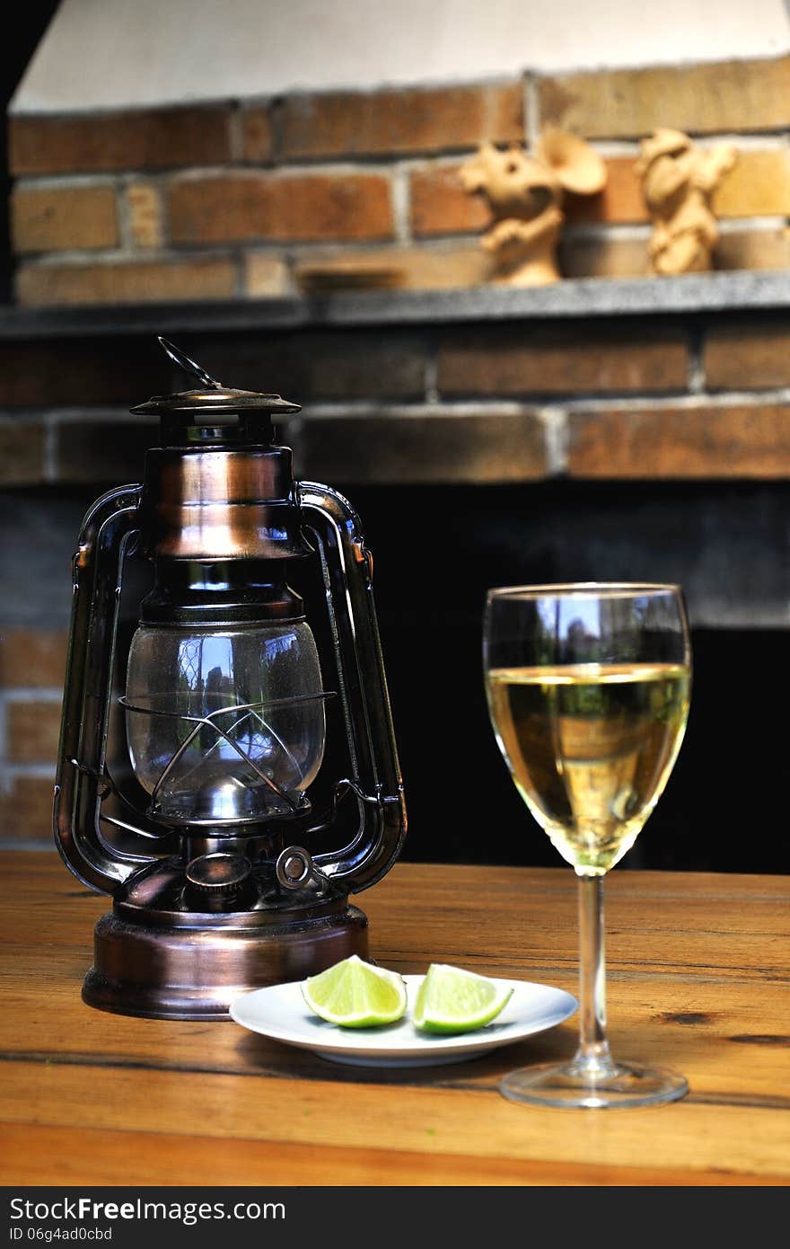 Wine glass, lamp and lemon on the dessert plate. Wine glass, lamp and lemon on the dessert plate