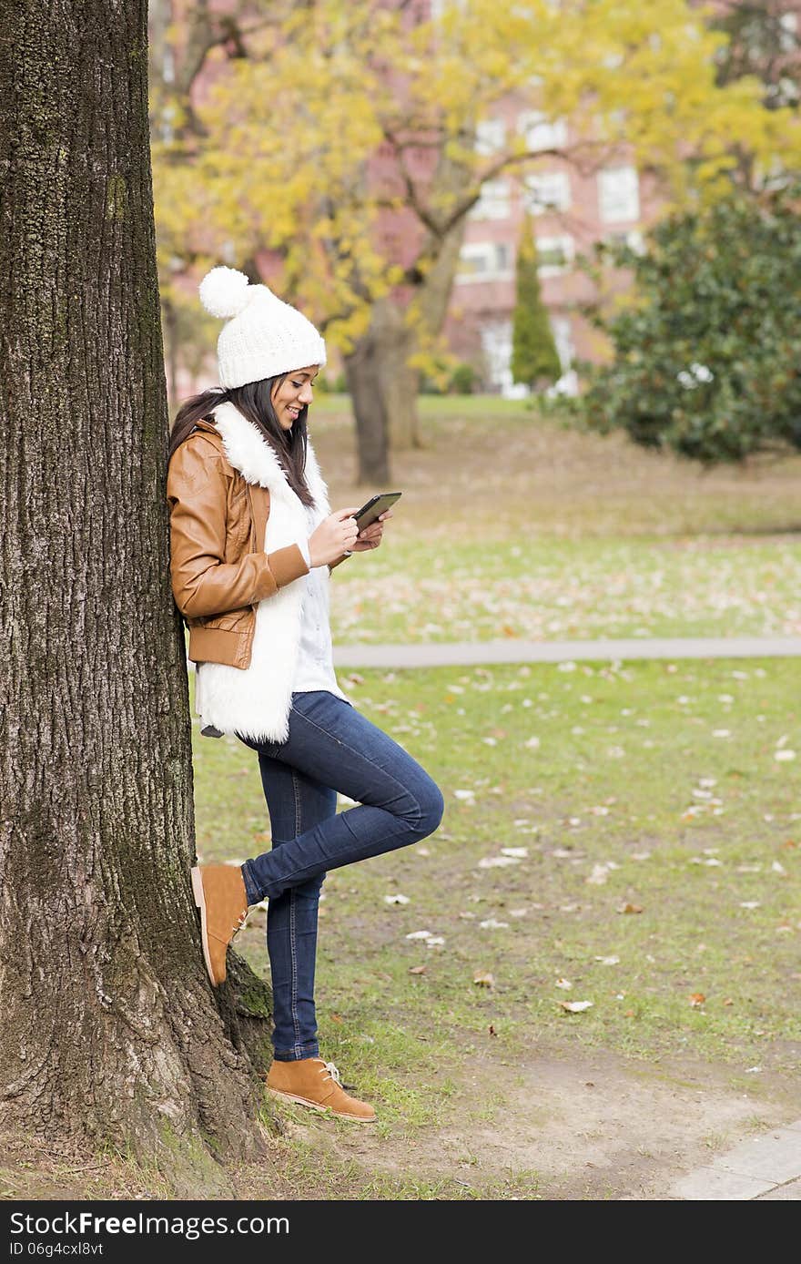 Smiling girl using tablet computer in the park. Smiling girl using tablet computer in the park.