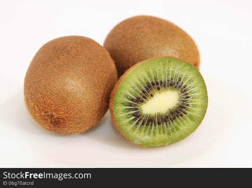 Whole kiwi fruit and it's sliced segments isolated on white background