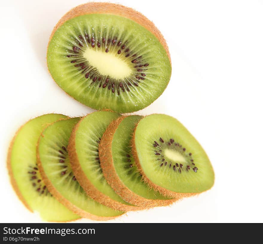 Whole kiwi fruit and it's sliced segments isolated on white background