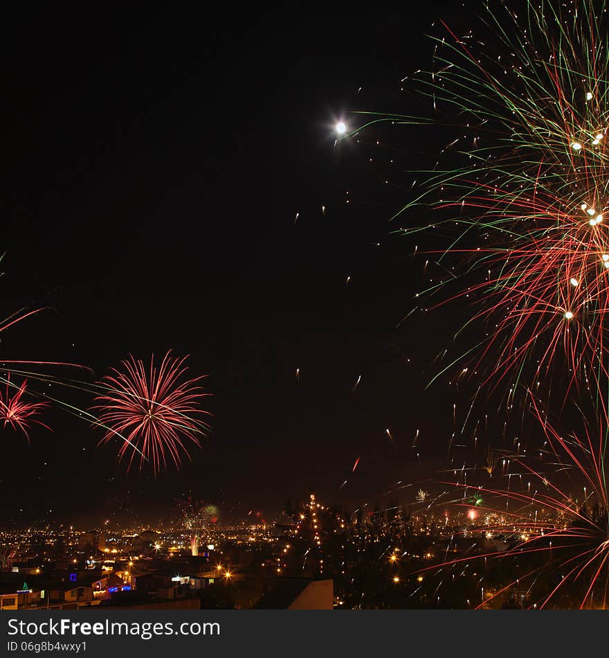 New year's eve fireworks in the city of Arequipa, Peru. Square image with moon in the picture. New year's eve fireworks in the city of Arequipa, Peru. Square image with moon in the picture