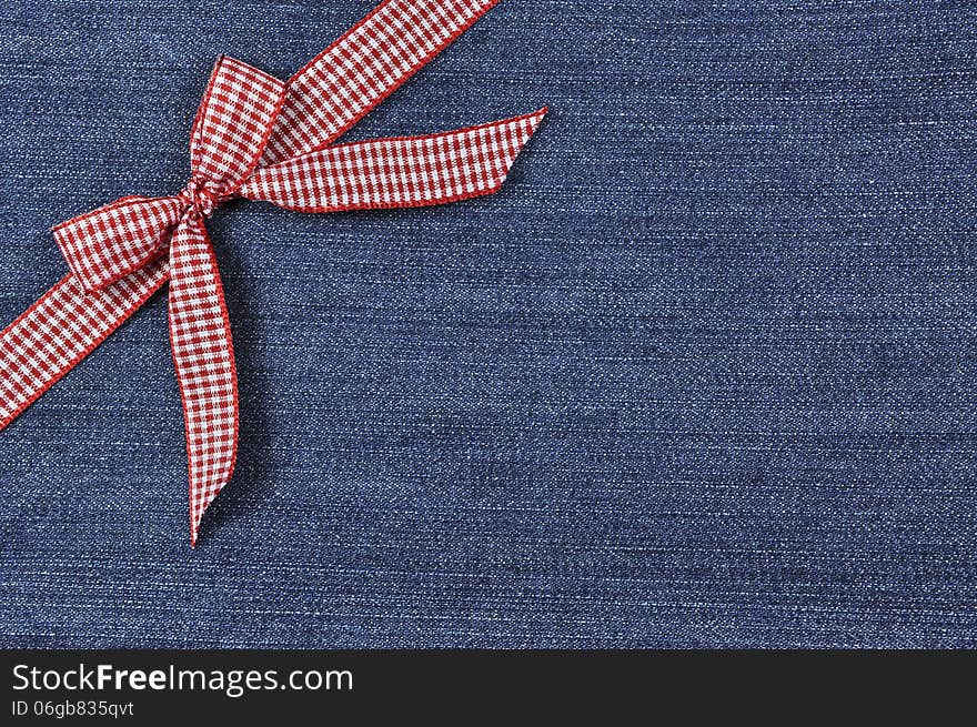 Red ribbon on a blue jeans background