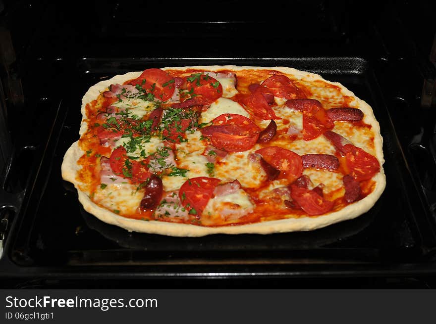 Ready home pizza in open black oven