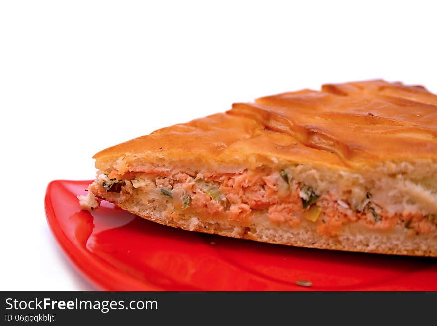 A piece of a fish pie on a red plate