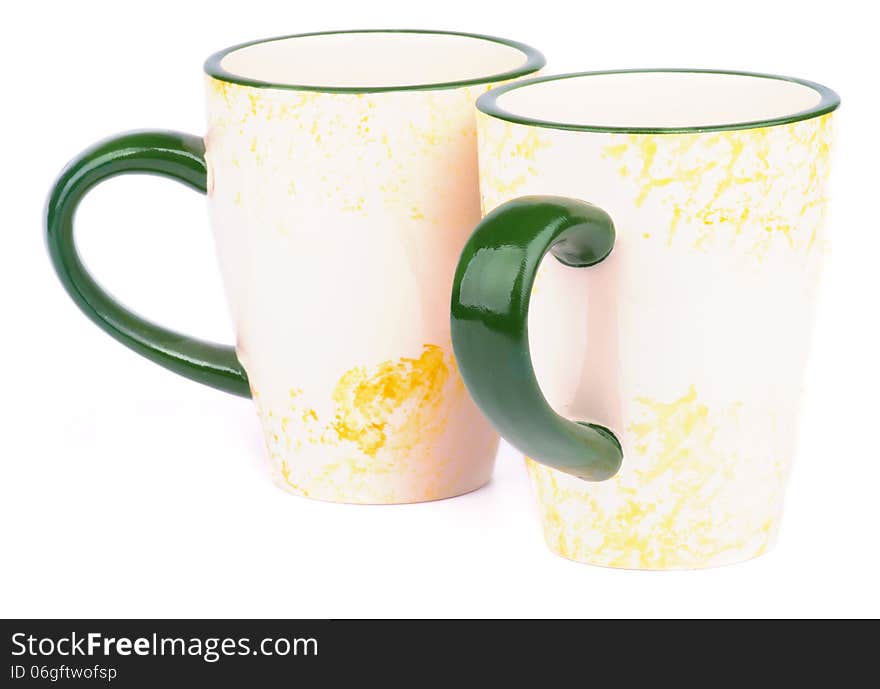 Pair of Beige Tea Cups with Green Handles isolated on white background. Pair of Beige Tea Cups with Green Handles isolated on white background